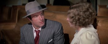Movie still from “Funny Lady” (1975), directed by Herbert Ross – A man wearing a suit and a hat talking to a woman; Close Up shot, Over the shoulder angle