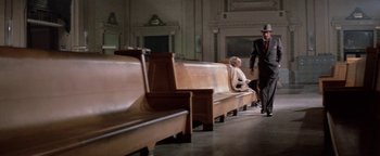 Movie still from “Funny Lady” (1975), directed by Herbert Ross – A man and a woman sitting on a bench in a church; Wide shot, High angle