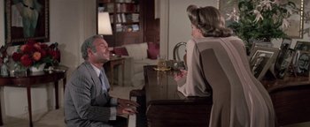 Movie still from “Funny Lady” (1975), directed by Herbert Ross – An older man sitting at a piano with a woman; Medium shot, High angle