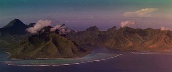 Movie still from “Hawaii” (1966), directed by George Roy Hill – An aerial view of a body of water with mountains in the background; Extreme Wide shot, High angle