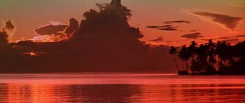 Movie still from “Hawaii” (1966), directed by George Roy Hill – A red sky with clouds and palm trees in the background; Extreme Wide shot, Low angle