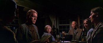 Movie still from “Hawaii” (1966), directed by George Roy Hill – A man sitting at a dinner table with a child and an older man; Medium shot, Low angle
