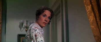 Movie still from “Hawaii” (1966), directed by George Roy Hill – A woman in a white shirt is standing in a room; Close Up shot, Low angle