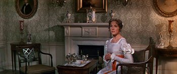 Movie still from “Hawaii” (1966), directed by George Roy Hill – A woman sitting in front of a fireplace in a living room; Medium shot, Over the shoulder angle