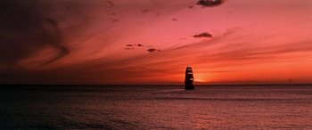 Movie still from “Hawaii” (1966), directed by George Roy Hill – A sailboat sailing on the ocean at sunset; Extreme Wide shot, Low angle