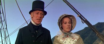 Movie still from “Hawaii” (1966), directed by George Roy Hill – A man and a woman standing next to each other in front of a sky background; Medium shot, Low angle