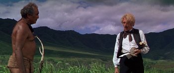 Movie still from “Hawaii” (1966), directed by George Roy Hill – A man standing in a field with mountains in the background; Wide shot, Low angle