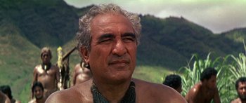 Movie still from “Hawaii” (1966), directed by George Roy Hill – An older man is looking at the camera while standing in a field; Close Up shot, Over the shoulder angle