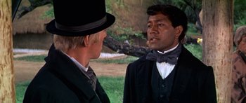 Movie still from “Hawaii” (1966), directed by George Roy Hill – A man in a top hat talking to another man in a suit and top hat; Close Up shot, Over the shoulder angle