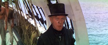 Movie still from “Hawaii” (1966), directed by George Roy Hill – A man wearing a top hat standing under an umbrella; Close Up shot, Low angle