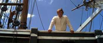 Movie still from “Hawaii” (1966), directed by George Roy Hill – A man standing on top of a boat in the water; Medium shot, Low angle