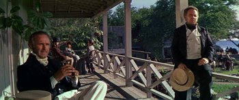 Movie still from “Hawaii” (1966), directed by George Roy Hill – A group of people sitting on top of a wooden deck; Wide shot, Low angle
