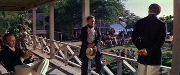 Movie still from “Hawaii” (1966), directed by George Roy Hill – A man standing on the porch of a house; Wide shot, High angle