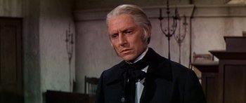 Movie still from “Hawaii” (1966), directed by George Roy Hill – An older man wearing a black suit and a black bow tie; Close Up shot, Low angle
