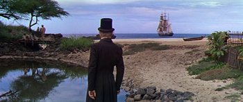 Movie still from “Hawaii” (1966), directed by George Roy Hill – A man wearing a top hat and a long coat looking out at a ship; Extreme Wide shot, High angle