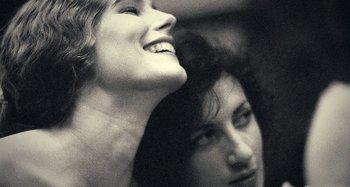 Movie still from “House of Tolerance” (2011), directed by Bertrand Bonello – Two women are smiling for the camera in black and white; Close Up shot, Low angle