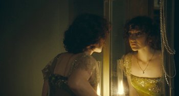 Movie still from “House of Tolerance” (2011), directed by Bertrand Bonello – A woman looking at herself in the mirror; Medium shot, Over the shoulder angle