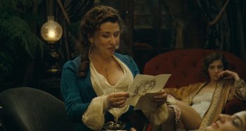 Movie still from “House of Tolerance” (2011), directed by Bertrand Bonello – A woman holding a drawing in her hands; Medium shot, Over the shoulder angle