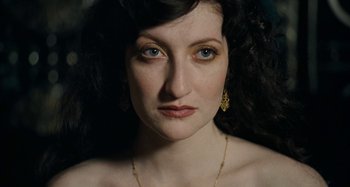 Movie still from “House of Tolerance” (2011), directed by Bertrand Bonello – A person wearing a necklace and earrings; Close Up shot, High angle