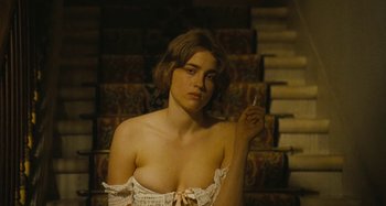 Movie still from “House of Tolerance” (2011), directed by Bertrand Bonello – A woman in a white dress sitting in front of a staircase; Close Up shot, Over the shoulder angle