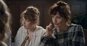 Movie still from “House of Tolerance” (2011), directed by Bertrand Bonello – Two women sitting next to each other while one of them is holding a fork in her hand; Close Up shot, High angle