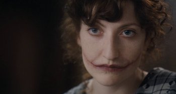 Movie still from “House of Tolerance” (2011), directed by Bertrand Bonello – A person's face with blue eyes; Close Up shot, Over the shoulder angle