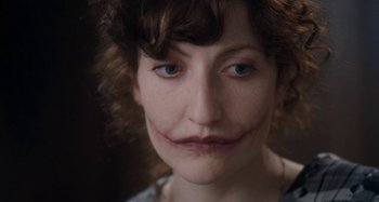 Movie still from “House of Tolerance” (2011), directed by Bertrand Bonello – A person with a joker make - up on; Close Up shot, Over the shoulder angle