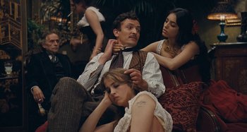 Movie still from “House of Tolerance” (2011), directed by Bertrand Bonello – A group of people sitting on the ground; Medium shot, High angle