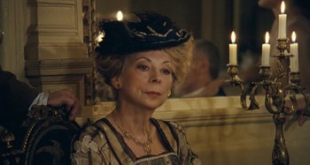 Movie still from “House of Tolerance” (2011), directed by Bertrand Bonello – An older woman wearing a hat and a necklace; Close Up shot, Low angle
