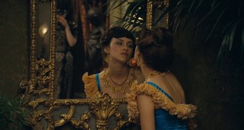 Movie still from “House of Tolerance” (2011), directed by Bertrand Bonello – A woman in a blue and yellow dress looking in a mirror; Medium shot, Over the shoulder angle