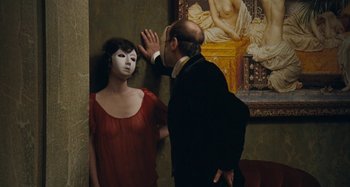 Movie still from “House of Tolerance” (2011), directed by Bertrand Bonello – A man in a black suit and a woman in a red dress; Medium shot, Over the shoulder angle