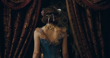 Movie still from “House of Tolerance” (2011), directed by Bertrand Bonello – A woman in a blue dress with a flower in her hair; Medium shot, Over the shoulder angle