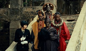 Movie still from “Hyenas” (1992), directed by Djibril Diop Mambéty – A group of women dressed in traditional african clothing; Medium shot, Low angle