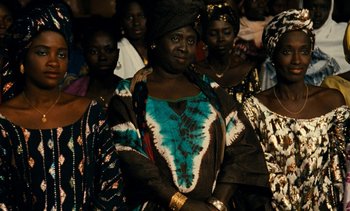 Movie still from “Hyenas” (1992), directed by Djibril Diop Mambéty – A group of women standing next to each other; Medium shot, High angle