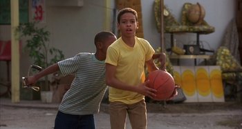 Movie still from “Jason's Lyric” (1994), directed by Doug McHenry – Two young boys are playing a game of basketball; Medium shot, Low angle