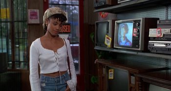 Movie still from “Jason's Lyric” (1994), directed by Doug McHenry – A woman standing in front of a television in a store; Medium shot, Over the shoulder angle