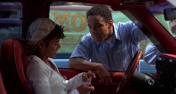 Movie still from “Jason's Lyric” (1994), directed by Doug McHenry – A man and a woman sitting in the back seat of a car; Medium shot, Low angle