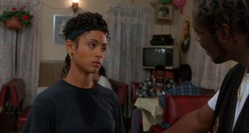 Movie still from “Jason's Lyric” (1994), directed by Doug McHenry – A woman in a black shirt is in a living room; Close Up shot, Over the shoulder angle