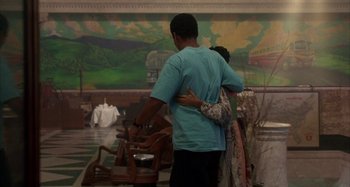 Movie still from “Jason's Lyric” (1994), directed by Doug McHenry – A man and a woman are hugging in front of a painting; Wide shot, Low angle