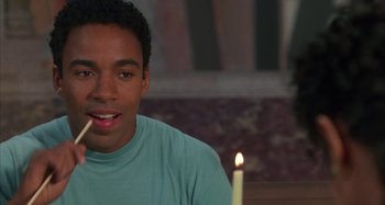 Movie still from “Jason's Lyric” (1994), directed by Doug McHenry – A man sitting in front of a lit candle; Close Up shot, Over the shoulder angle