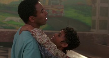 Movie still from “Jason's Lyric” (1994), directed by Doug McHenry – A man and a woman hugging each other in front of a fire truck; Close Up shot, Over the shoulder angle