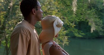 Movie still from “Jason's Lyric” (1994), directed by Doug McHenry – A man and a woman standing next to each other near a body of water; Medium shot, Low angle