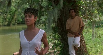 Movie still from “Jason's Lyric” (1994), directed by Doug McHenry – A woman standing next to a man leaning against a tree; Medium shot, Over the shoulder angle