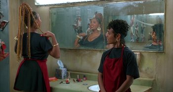 Movie still from “Jason's Lyric” (1994), directed by Doug McHenry – Two people in a room with a painting of a woman; Medium shot, Over the shoulder angle