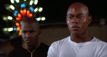 Movie still from “Jason's Lyric” (1994), directed by Doug McHenry – A couple of men standing next to each other in a room; Close Up shot, Low angle