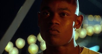 Movie still from “Jason's Lyric” (1994), directed by Doug McHenry – A man's face in front of lights; Close Up shot, Low angle