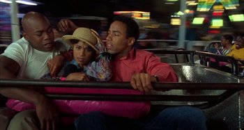 Movie still from “Jason's Lyric” (1994), directed by Doug McHenry – A man and a child riding a train together; Medium shot, High angle