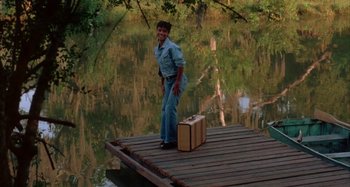 Movie still from “Jason's Lyric” (1994), directed by Doug McHenry – A man standing on a pier with a suitcase; Wide shot, High angle