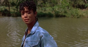 Movie still from “Jason's Lyric” (1994), directed by Doug McHenry – A young woman standing in front of a body of water; Close Up shot, Over the shoulder angle