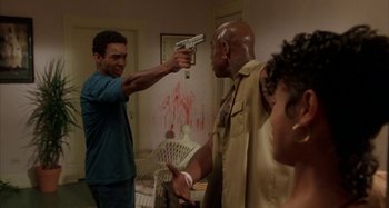 Movie still from “Jason's Lyric” (1994), directed by Doug McHenry – A man holding a gun up to another man's face; Medium shot, Low angle